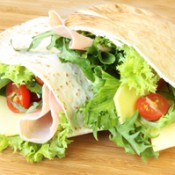 Pita sandwich with lettuce and tomato in it.