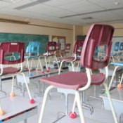 Classroom with chairs on top of desks.