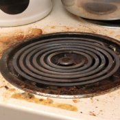 Dirty drip pan and stove top.