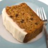 A piece of carrot cake on plate with cream cheese frosting