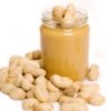 Jar of peanut butter surrounded by peanuts.
