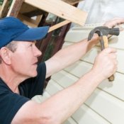 Saving Money on Home Repairs, Man Repairing the Siding on His Home