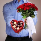 Valentine's Day Tips for Men, Man giving a heart shaped chocolate box and roses.
