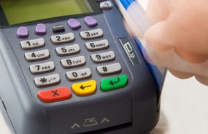 Swiping a credit card through a machine.