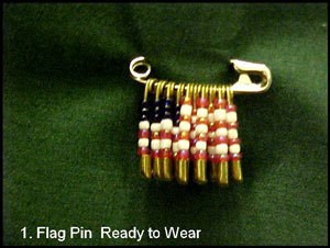 A safety pin with beads in a flag pattern.