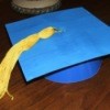 A homemade blue graduation cap with a golden tassle.