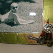 A frame with decorations from a junk drawer, such as a key.