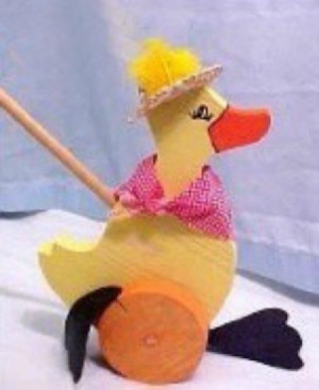 A yellow duck push toy made out of wood.