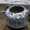 A teakettle that has been painted white and black.