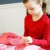 A photo of a girl making paper hearts.