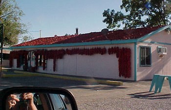 Hot peppers drying on the roof of a house.