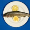 A fish on a plate with lemon.