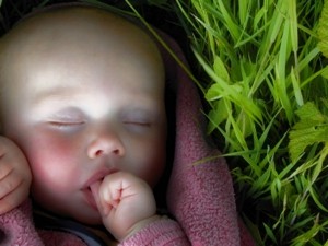 baby sleeping by grass