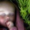 baby sleeping by grass
