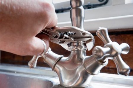 Plumber fixing a leaky faucet.