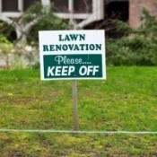 Recently seeded lawn with a keep off sign.