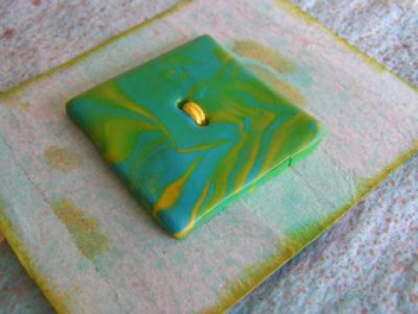 Marbled green and gold clay button.