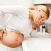 Pregnant woman with morning sickness near bathroom sink