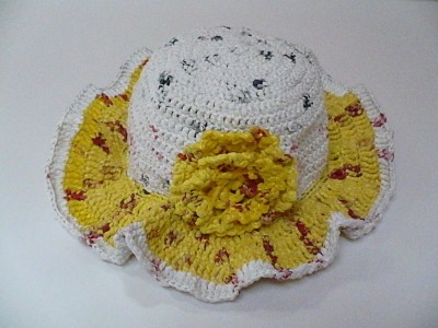 Yellow and white hat made out of plarn.