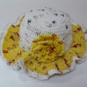 Yellow and white hat made out of plarn.