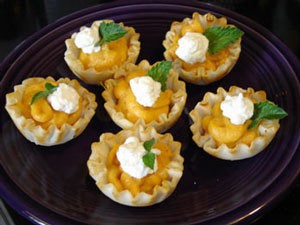 A plate of mini pumpkin tarts.