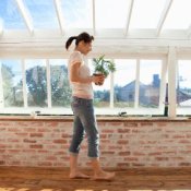 A woman stand in a room built using recycled windows.