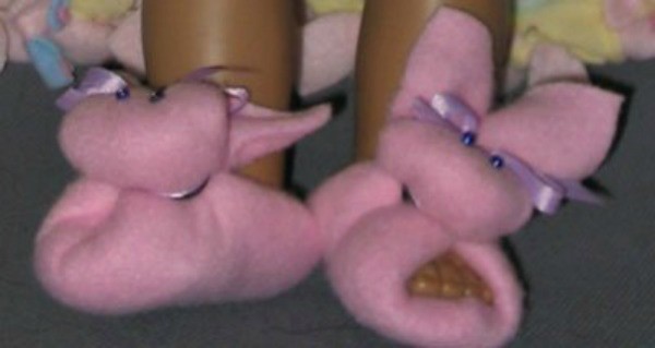 Pink fleece doll slippers shaped like bunnies.