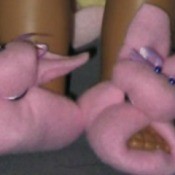 Pink fleece doll slippers shaped like bunnies.