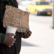 A homeless person holding up a sign