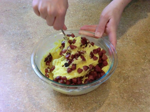 Mixing hotdogs into the batter.