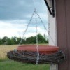 A hanging bird bath made with a grapevine.