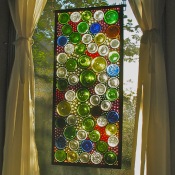 A stained glass window using cut wine bottle bottoms.