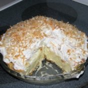 A coconut cream pie with one slice removed.