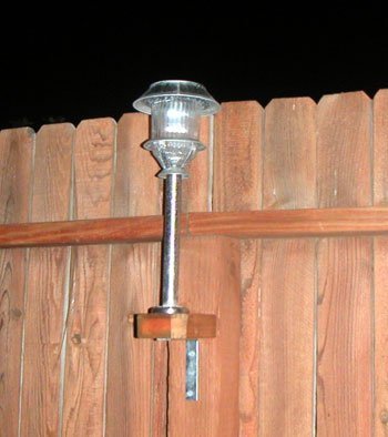 Attach Solar Lights to Your Fence - Solar light attached to a fence shown at night.