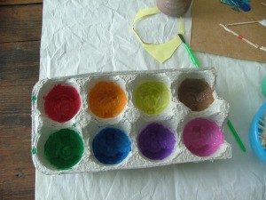 An egg carton being used for finger paints.