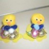 Two pom pom chicks holding Easter candy.