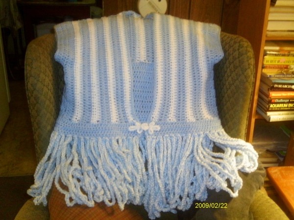 Crocheted Calypso Cardigan, front side displayed on a chair.