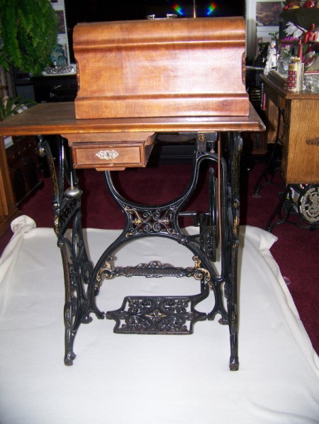 Wooden cabinet coffin style sewing machine.