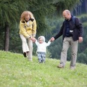 Mother and Father Helping Child with First Steps