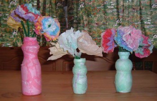 Drinkable yogurt bottle vases with paper flowers.