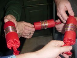 Hands holding holiday crackers in a circle