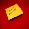 Yellow Post-it note on red background.