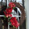A red silk flower and grapevine wreath