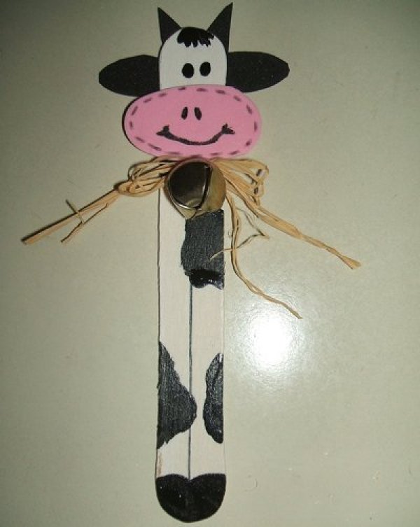 A whimsical cow bookmark in black and white and pink with a rustic bow..