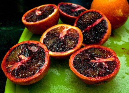 Several blood oranges cut in half.