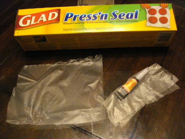 The Super glue tube is wrapped up inside a square of Press'N Seal plastic wrap.