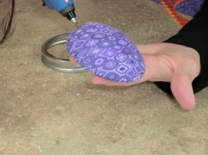 Applying hot glue to pincushion.