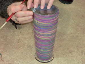 Gluing end of yarn.