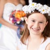 Flower Girl Smiling in Front of Bride and Groom