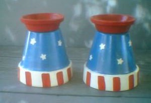 A pair of Fourth of July candle holders made from clay pots.